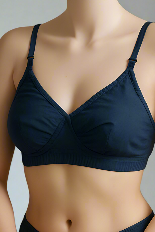 Person wearing a navy blue bra and underwear set on a beige background
