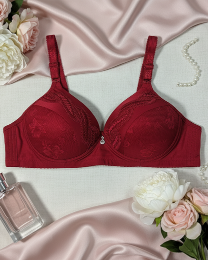 Red bra on a satin surface with flowers and a perfume bottle