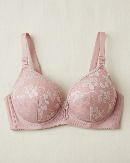 Pink bra with floral lace details on a light beige background